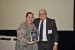 Dr. Nagib Callaos, General Chair, giving Dr. María Lourdes López López a plaque "Por su Excelente Ponencia Plenaria."